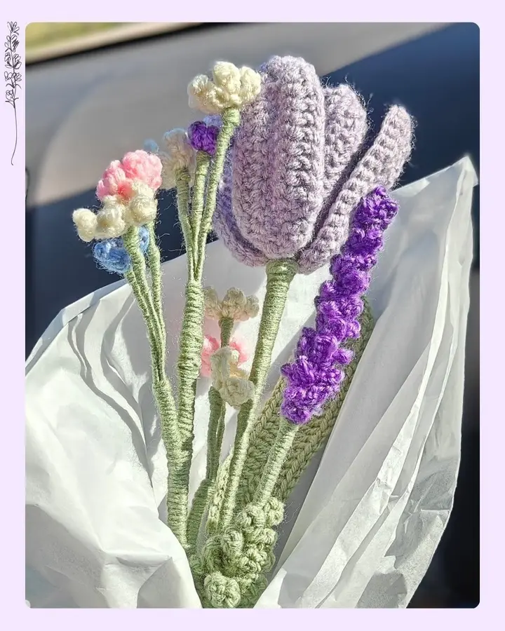 A crocheted purple tulip with wired petals and a wooden stem