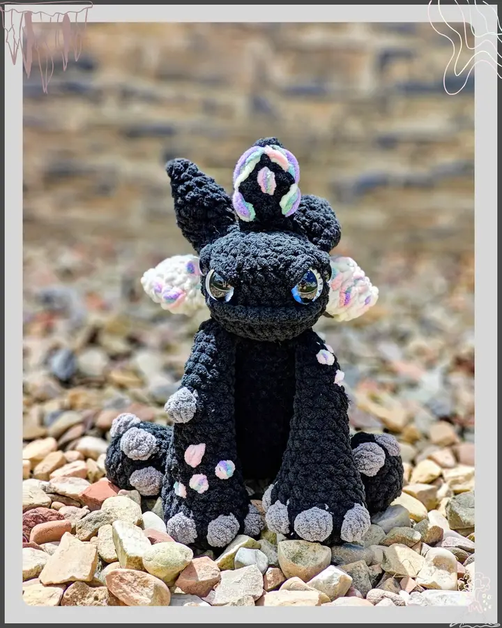 Vexley the Voidscale, a deep purple and black crocheted dragon with pointed wings, posed upright against a soft background